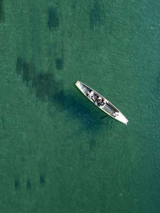 Vogelperspektive auf den smaragdgrün schimmernden Rhein. Ein Weidling treibt mit der Strömung.